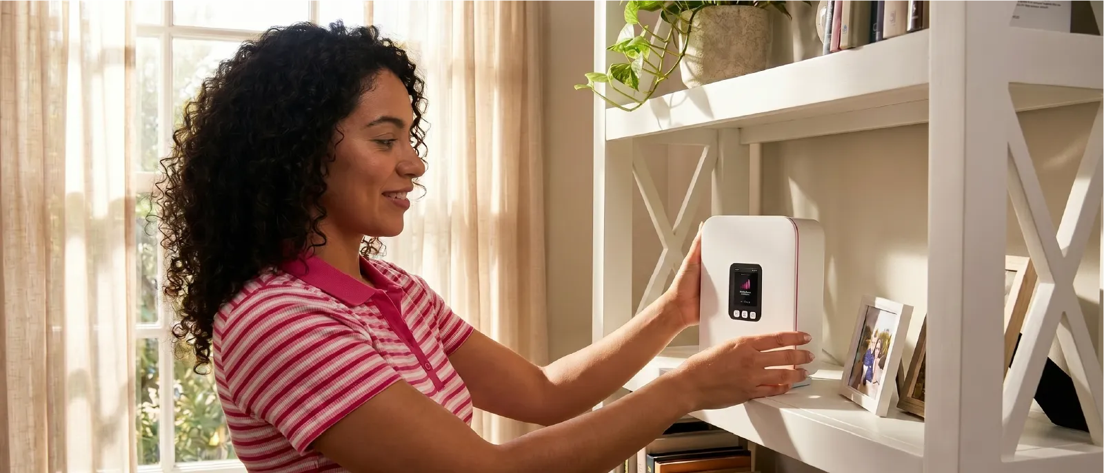 Woman placing her 5G home gateway router on a shelf close to the window